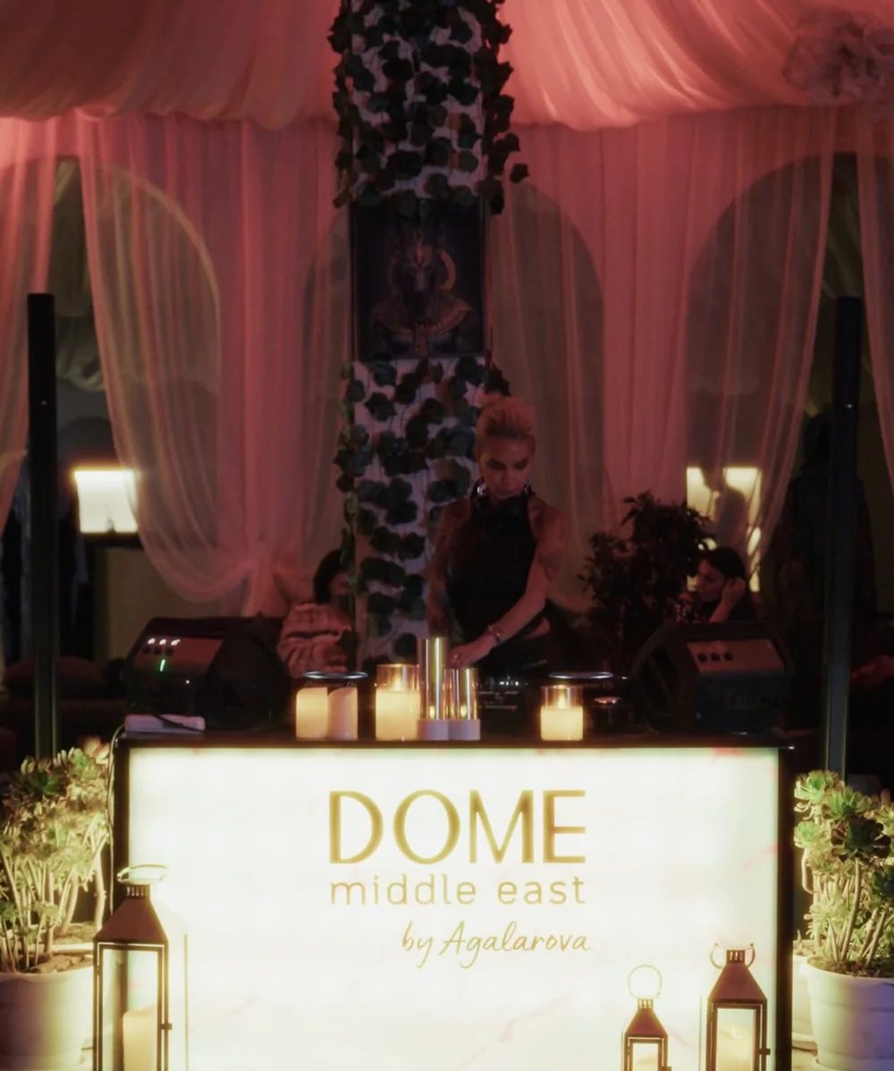 Стойка диджея с подсвеченным логотипом «DOME middle east by Agalarova», свечи и латунные фонари